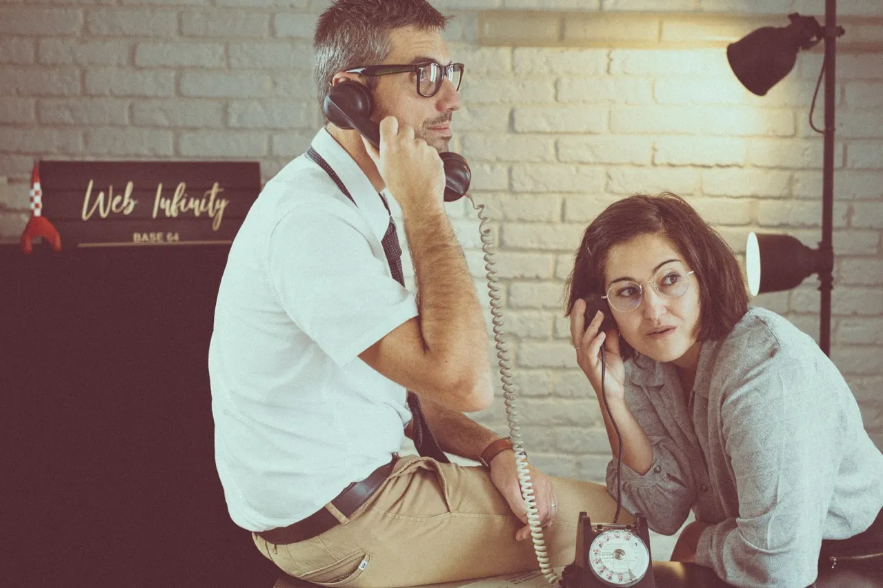 Alexandre et Noélène, chacun au téléphone, sous l'enseigne Web-Infinity